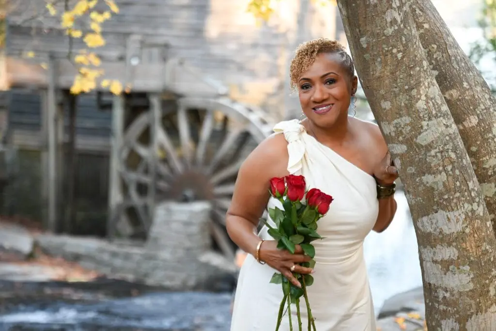 Woman posing for family photoshoot in Atlanta parks with water mill on the back