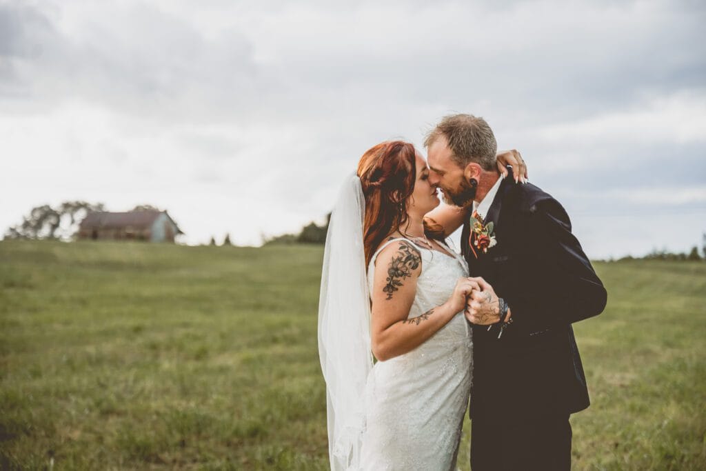 Wedding couple kissing next to a barn